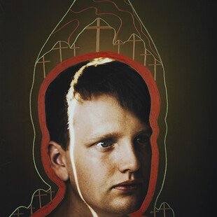 Portrait of a young boy with crosses and a red and green outline around his head and shoulders