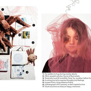Portrait of a young woman next to the items in her mental health kit - toy spiders, other people's photos, book, writing journal, poem, photograph of parents, travel souvenirs
