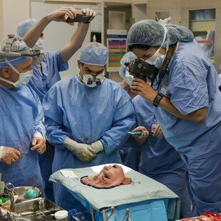 Doctors around a donor's face after it was surgically removed and before transplant