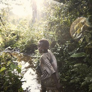 An Mbuti boy runs through the Ituri rainforest.