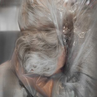 A mother and daughter hug through plastic sheeting, during the Covid-19 pandemic.
