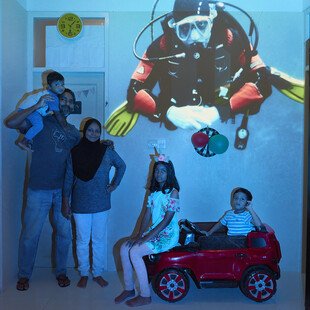 An underwater image is projected behind a family.